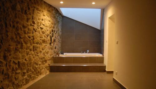 蒙塔巴諾艾利寇納的住宿－Yuba - Aragon home holiday，带浴缸和石墙的浴室。