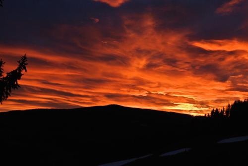 a sunset over a mountain with the sun setting at Glühwürmchenhütte in Ratten
