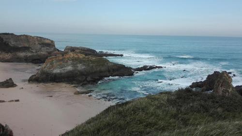 an aerial view of a beach with rocks and the ocean at Casa Tésera in El Franco