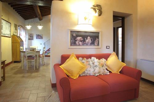 a living room with a red couch with yellow pillows at Agriturismo Villa Le Vigne in Montevarchi