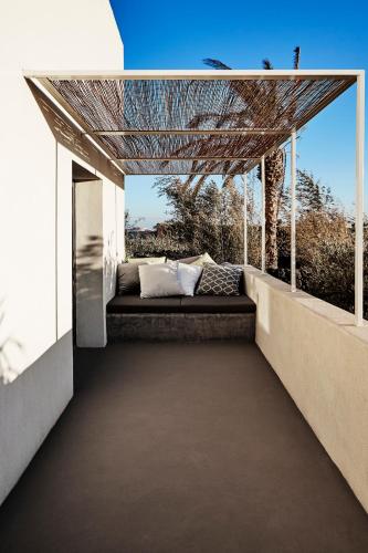 a couch on the balcony of a house at Sikelia Luxury Hotel in Pantelleria