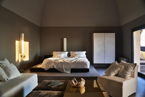 a bedroom with a bed and a couch at Sikelia Luxury Hotel in Pantelleria