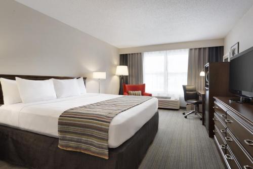 a hotel room with a large bed and a large window at Country Inn & Suites by Radisson, Houghton, MI in Houghton