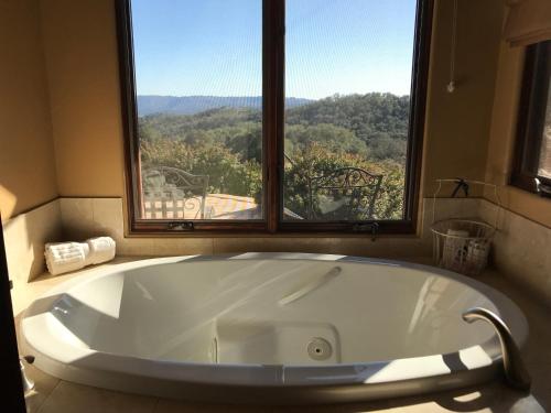eine große Badewanne im Bad mit Fenster in der Unterkunft Dunning Vineyards Guest Villa in Paso Robles