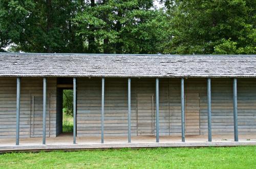 a wooden building with a gambrel roof at Niedras in Biksti