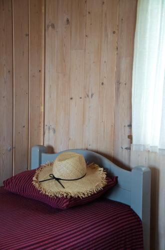 a straw hat sitting on top of a bed at Niedras in Biksti