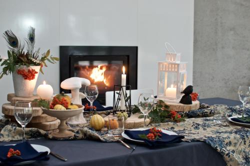 a thanksgiving table with a fireplace and a blue table cloth at Niedras in Biksti