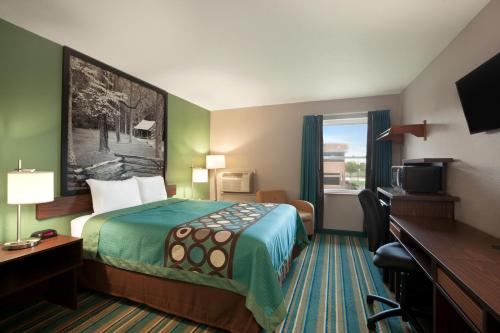 a hotel room with a bed and a desk at Super 8 by Wyndham Tuscola in Tuscola