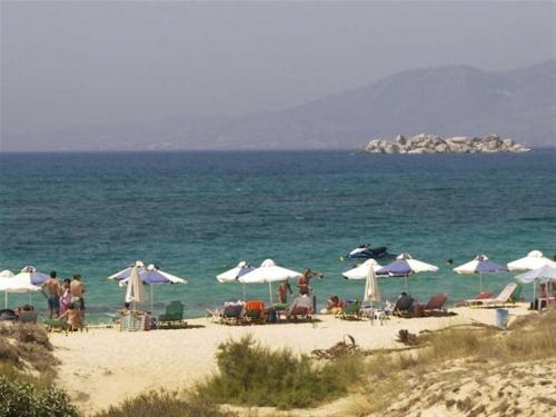 a group of people sitting on a beach with umbrellas at Aronis Plaka Naxos in Plaka
