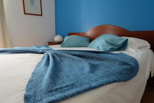 a blue blanket laying on top of a bed at Hotel Alcides in Ponta Delgada