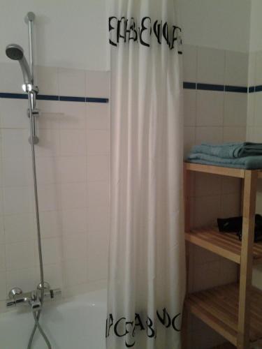 a shower curtain in a bathroom with a tub at Zonnig Appartement met Zeezicht in Koksijde