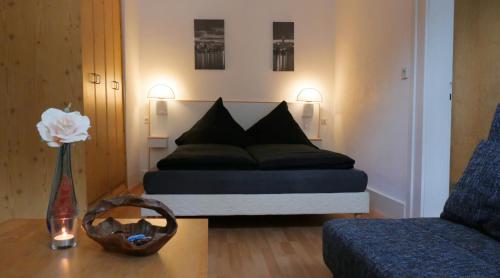 a bedroom with a bed and a vase with a flower on a table at Hotel zur Post in Wieda