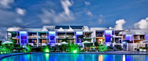 a hotel with a pool in front of a building at Hommage Hotel & Residences in Baie Nettle