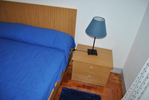 a bedroom with a bed and a lamp on a night stand at Tagus Host in Santarém