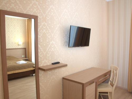 a room with a desk and a television on a wall at Staryj Kosiv in Staryi Kosiv