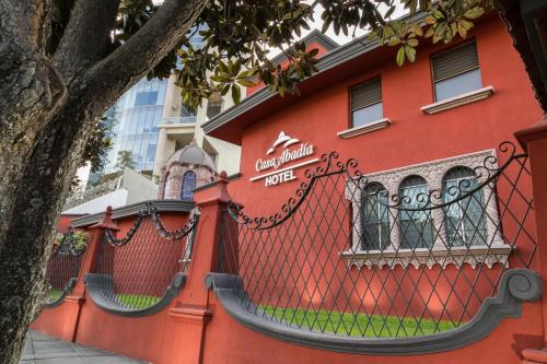 a red building with a fence in front of it at Hotel Boutique Abad in Guadalajara