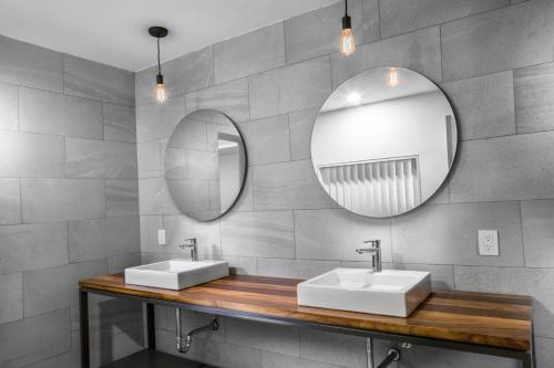 a bathroom with two sinks and a mirror at Hotel Boutique Abad in Guadalajara