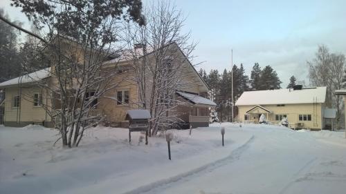 a house with snow on the ground in front at Hotelli Möhkön Rajakartano - Ilomantsi in Petkeljärvi