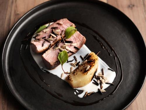 a black plate with some food on a table at The Crown in Amersham