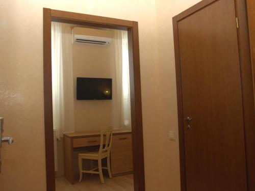 a room with a desk and a television and a door at Staryj Kosiv in Staryi Kosiv