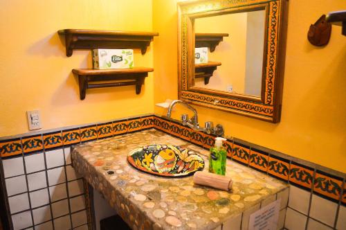 a bathroom with a sink and a mirror at Hotel Casamar Suites in Puerto Escondido