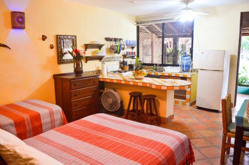 a kitchen with a refrigerator and a table with stools at Hotel Casamar Suites in Puerto Escondido
