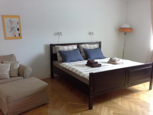 een slaapkamer met een bed met blauwe kussens en een bank bij Your Ljubljana Home in Ljubljana