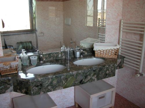 a bathroom with two sinks and a large mirror at B&B Alla Fiera in Ponte Galeria
