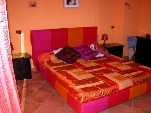 a bedroom with a colorful bed with two pillows on it at B&B Alla Fiera in Ponte Galeria