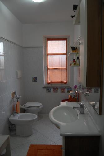 a bathroom with a sink and a toilet and a window at B&B Filomena in Santa Giusta