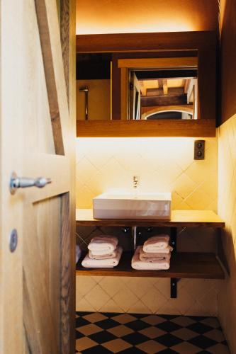 a bathroom with a sink and towels on a shelf at Het Zwaluwnest in Middelkerke