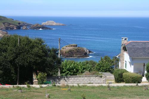 a small white house with a view of the ocean at Casa Tésera in El Franco