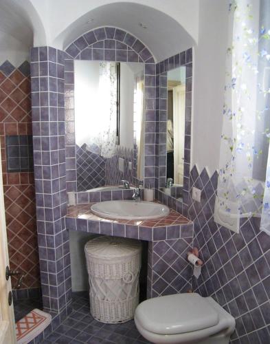 a bathroom with a sink and a toilet at Le Tre Pietre in Baja Sardinia