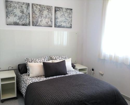 ラスパルマス・デ・グランカナリアにあるVenegas Homeのベッドルーム1室(壁に絵画3点が飾られたベッド1台付)