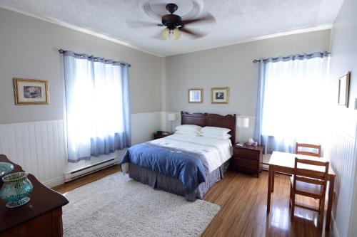 - une chambre avec un lit et un ventilateur de plafond dans l'établissement Auberge le St-Georges, à Saguenay
