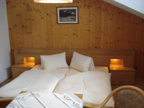 ein Schlafzimmer mit einem weißen Bett mit zwei Leuchten in der Unterkunft Lucknerhof in Kals am Großglockner