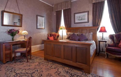 a bedroom with a bed and a desk and a desk at HH Whitney House - A Bed & Breakfast on the Historic Esplanade in New Orleans