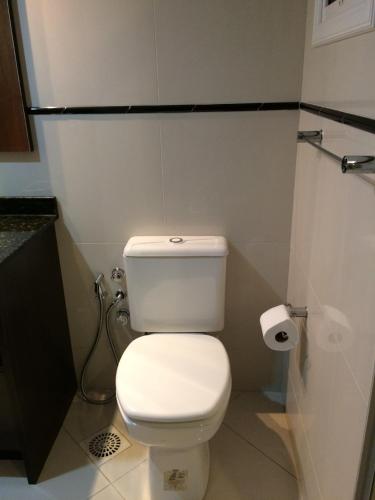 a bathroom with a white toilet and a roll of toilet paper at Apartamento Baviera in Canela