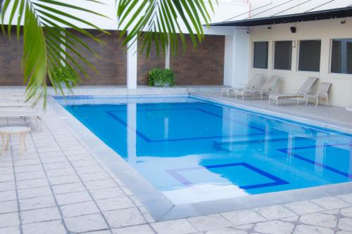 a swimming pool with blue water in a house at Hotel de Casa Blanca in Lázaro Cárdenas