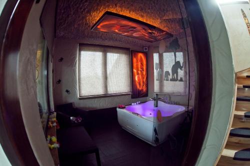 baño con lavabo púrpura en una habitación en Habibispa z JACUZZI pod chmurką MEGA OFERTA na stronie, en Stare Juchy