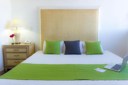 a bedroom with a bed with a laptop on it at Hotel de Casa Blanca in Lázaro Cárdenas