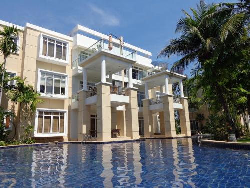 a large building with a swimming pool in front of it at Hua Hin Blue Lagoon in Cha Am