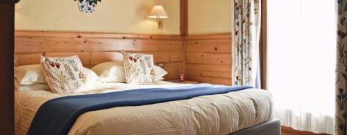 a bedroom with a bed with a blue blanket on it at Hotel Mignon in Breuil-Cervinia