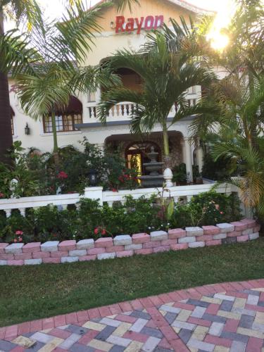 a building with a palm tree in front of it at Rayon Hotel in Negril