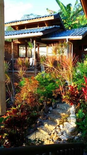 a garden in front of a house with plants at Horizon Hotel & Yoga Center in Santa Teresa Beach