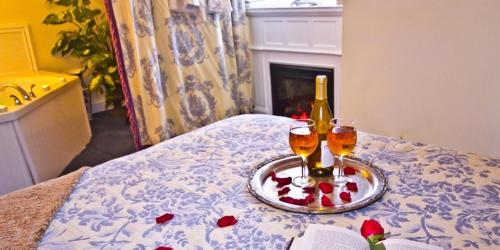 a bed with two glasses and a bottle of wine at Elk Forge Bed and Breakfast in Elkton