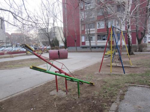 une aire de jeux avec plusieurs balançoires de couleurs différentes dans un parc dans l'établissement Studio Ema, à Niš