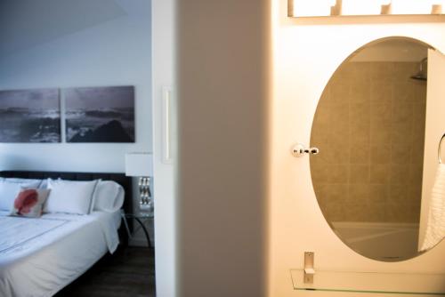 a bedroom with a bed and a mirror on the wall at The Francis Boutique Inn in Ucluelet