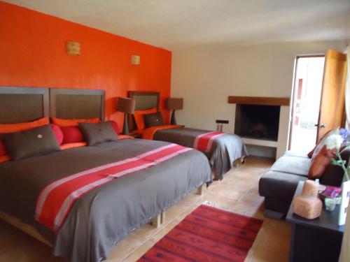 - une chambre d'hôtel avec 2 lits et une cheminée dans l'établissement La Casa del Rio, à Valle de Bravo
