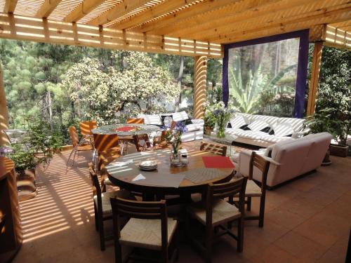 a patio with a table and chairs and a couch at La Casa del Rio in Valle de Bravo